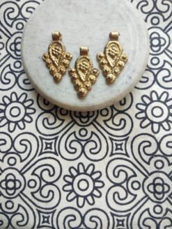 brass jewelry charms – Shop now: Close-up of artisan-crafted charms with intricate detailing.